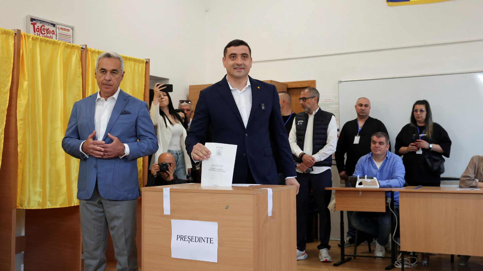Presidential candidate George Simion votes – with Calin Georgescu at his side. /Louisa Gouliamaki/Reuters